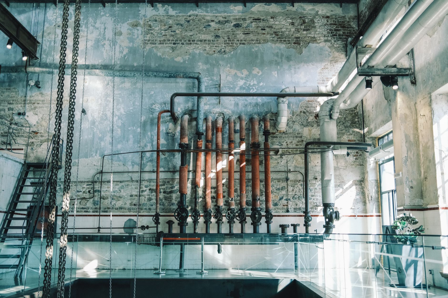 Vintage pipes and valves along a brick wall