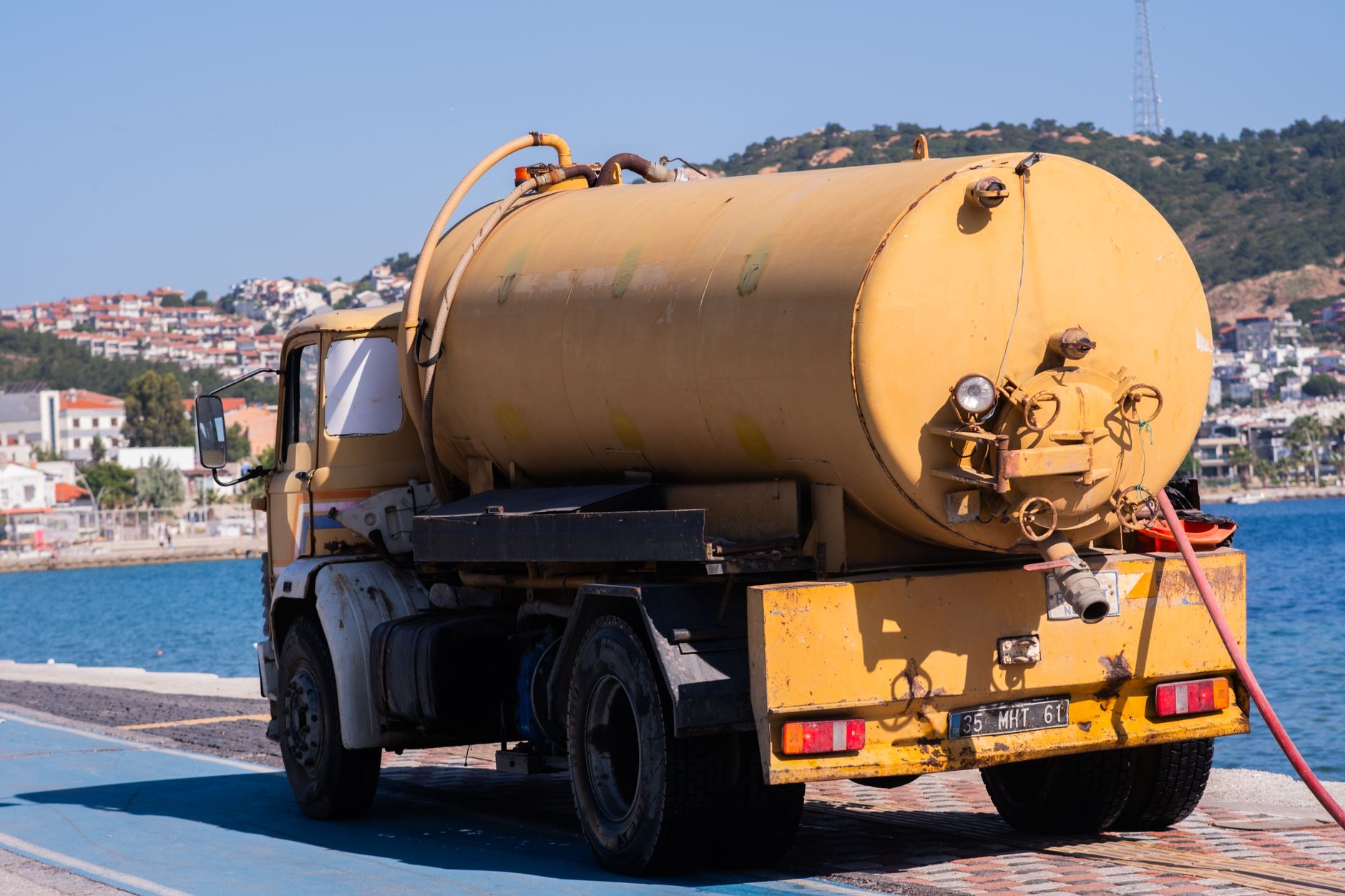 Yellow tank truck with hose equipment