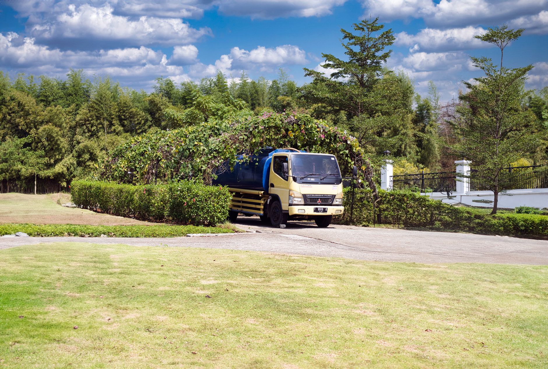 Service truck parked on a landscaped property under a clear sky